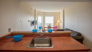 A kitchen with a sink, a countertop, and a dining area with a table and chairs. - Mount Saint Vincent University Residence - Hostel (Halifax)