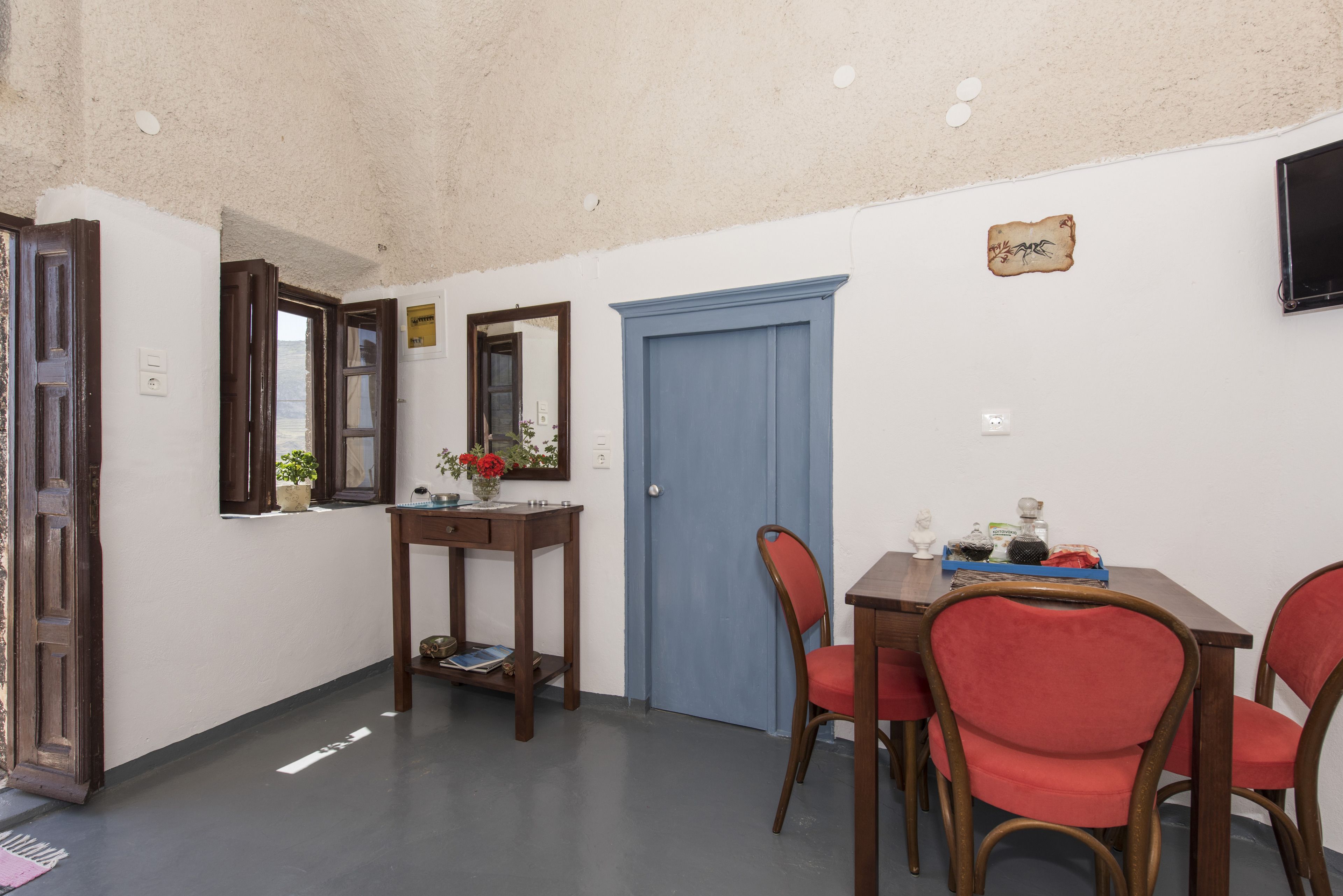 A dining area with a table, chairs, and a blue door.