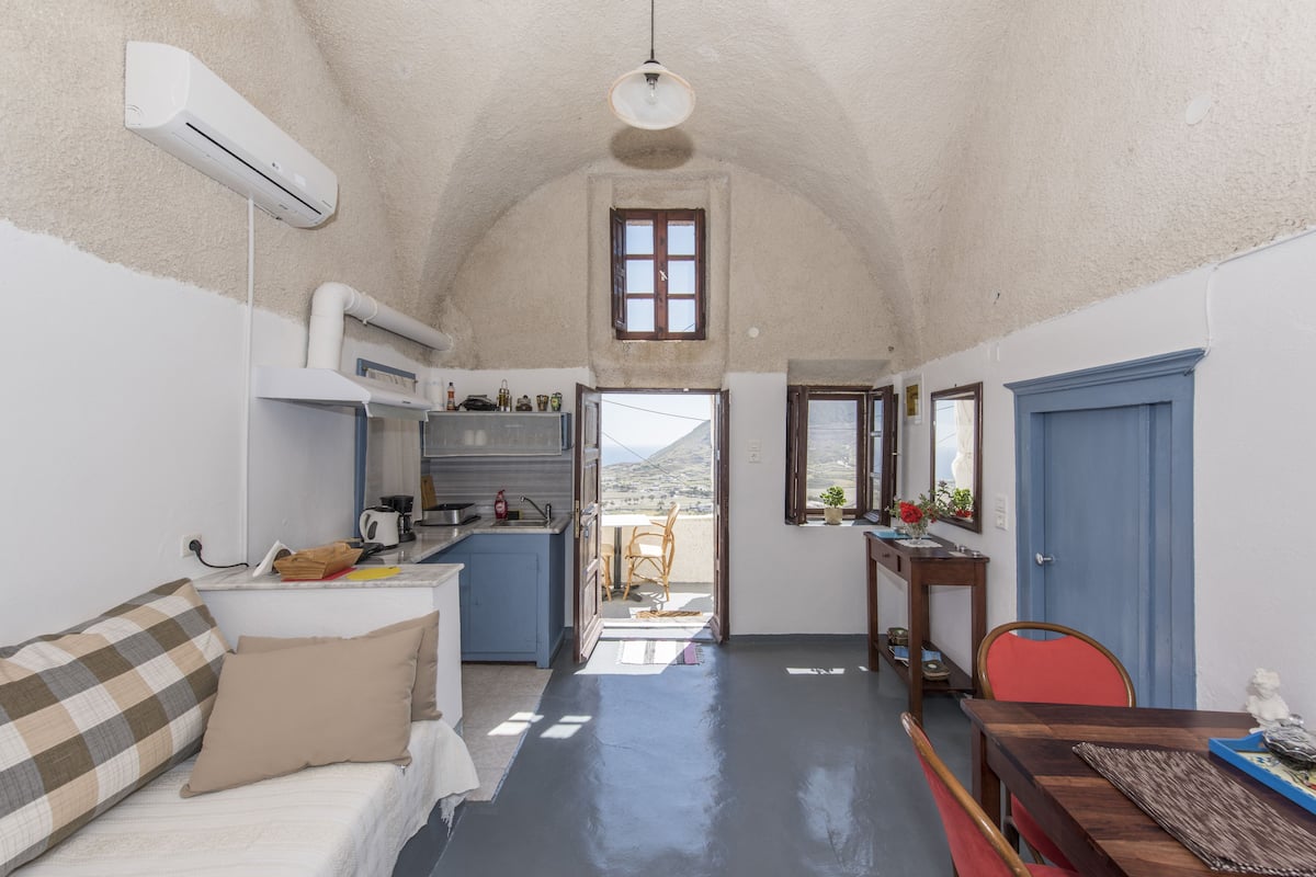 Un espacio habitable compacto con kitchenette, comedor y dormitorio.