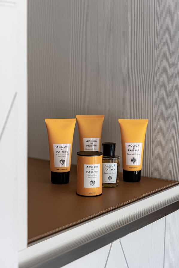 A shelf with three bottles of Acqua di Parma body lotion, a jar of body lotion, and a bottle of body cream. - White 1921 Courchevel (Courchevel)