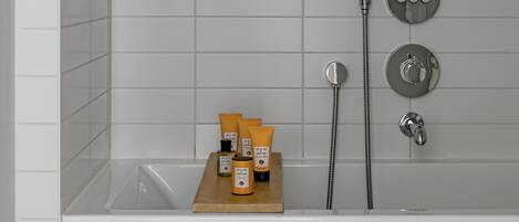A modern bathroom with a bathtub, a shower, and a towel rack.