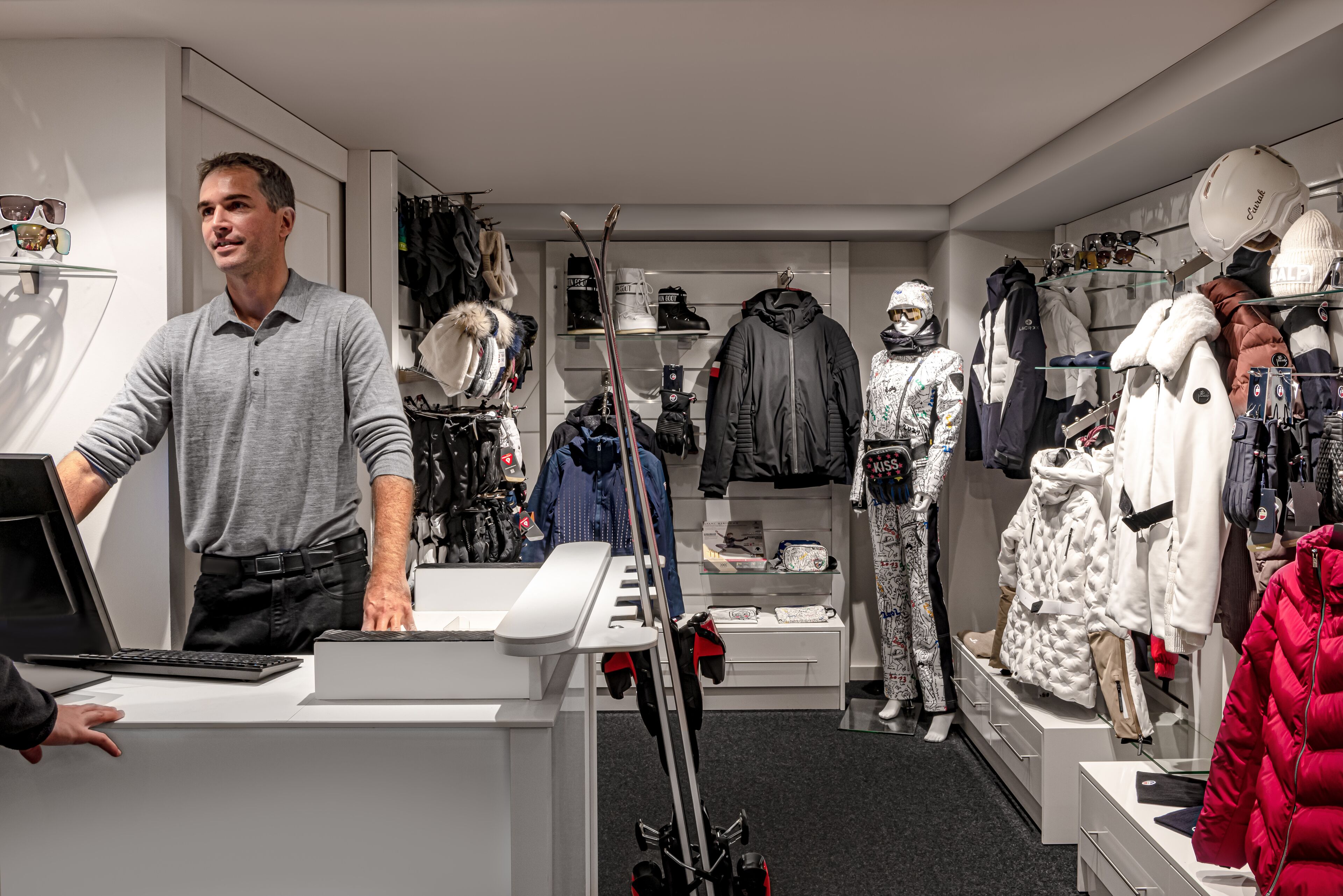 A modern retail store with a variety of winter clothing and accessories, including jackets, hats, and ski equipment.