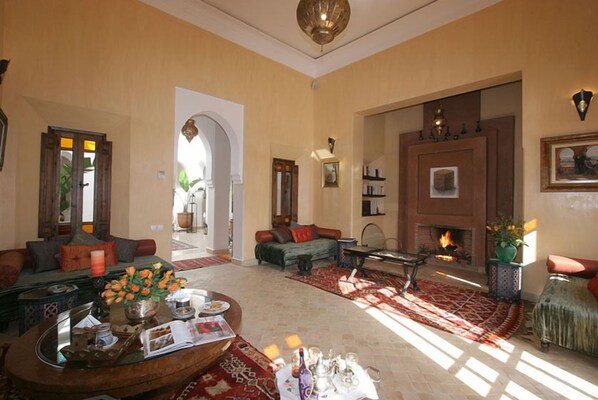 A spacious living room with a fireplace, comfortable seating, and a coffee table with decorative items.