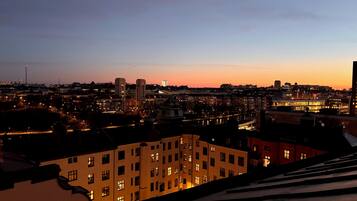 A cityscape at dusk with illuminated buildings and a clear sky.