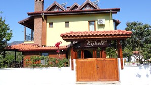 A hotel with a traditional design, featuring a prominent entrance with a wooden gate and a sign that reads "Kibell Hotel". - Kybele Hotel (Fethiye)