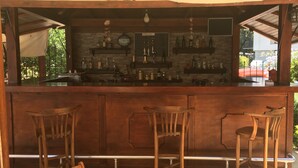 A bar area with wooden stools, a counter with bottles, and a 'Welcome' sign. - Kybele Hotel (Fethiye)