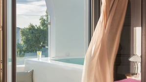 Una habitación con vistas a una piscina y árboles, una cama con edredón rosa y una ventana con cortina.