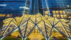 Un hotel modern amb una façana de vidre característica i una estructura d'entrada geomètrica única.