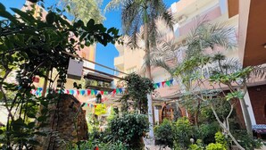 A courtyard with a stone wall, potted plants, and a tiled floor. - Amon Hotel (Luxor)