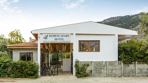 A modern hotel with a white facade, a signboard, and a paved entrance. - Kerem Apart Hotel Gocek (Fethiye)