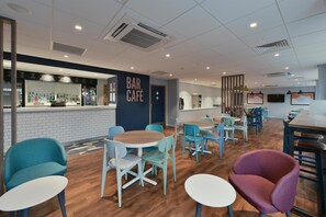A modern bar café with wooden flooring, teal and white chairs, and a bar area with a sign reading "BAR CAFE". - Travelodge Southampton Central (Southampton)