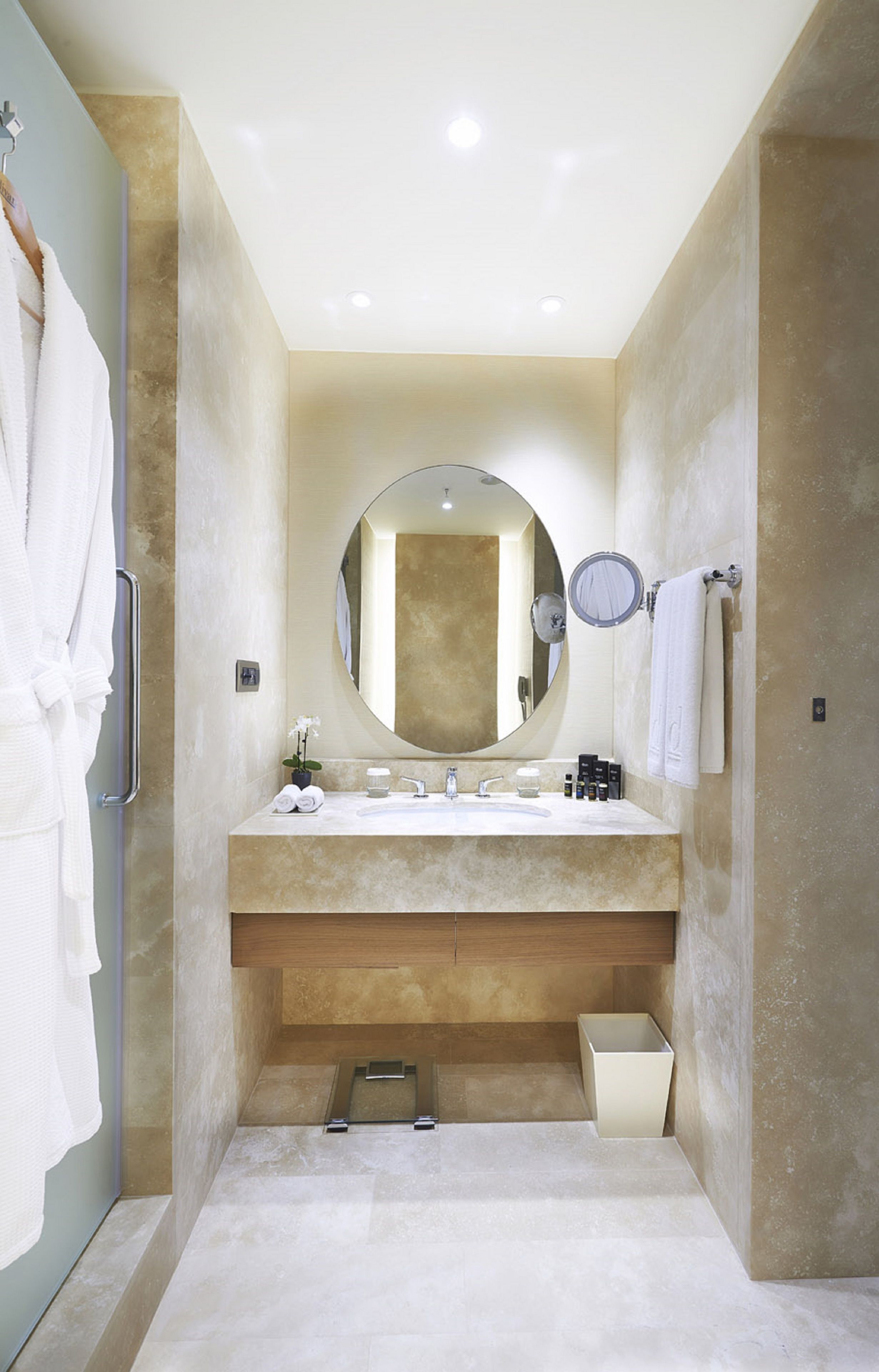 A modern bathroom with a large mirror, a sink, and a shower area.