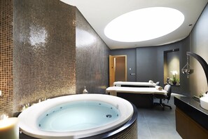 Un baño moderno con una bañera grande, una zona de ducha separada y un tocador con espejo.