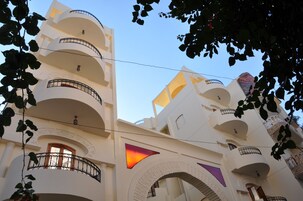 Un edificio de varios pisos con balcones, un diseño arquitectónico particular y un cielo despejado.