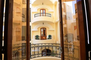 Un intérieur à plusieurs niveaux, doté de balcons, d’un escalier central et offrant une vue sur l’extérieur.
