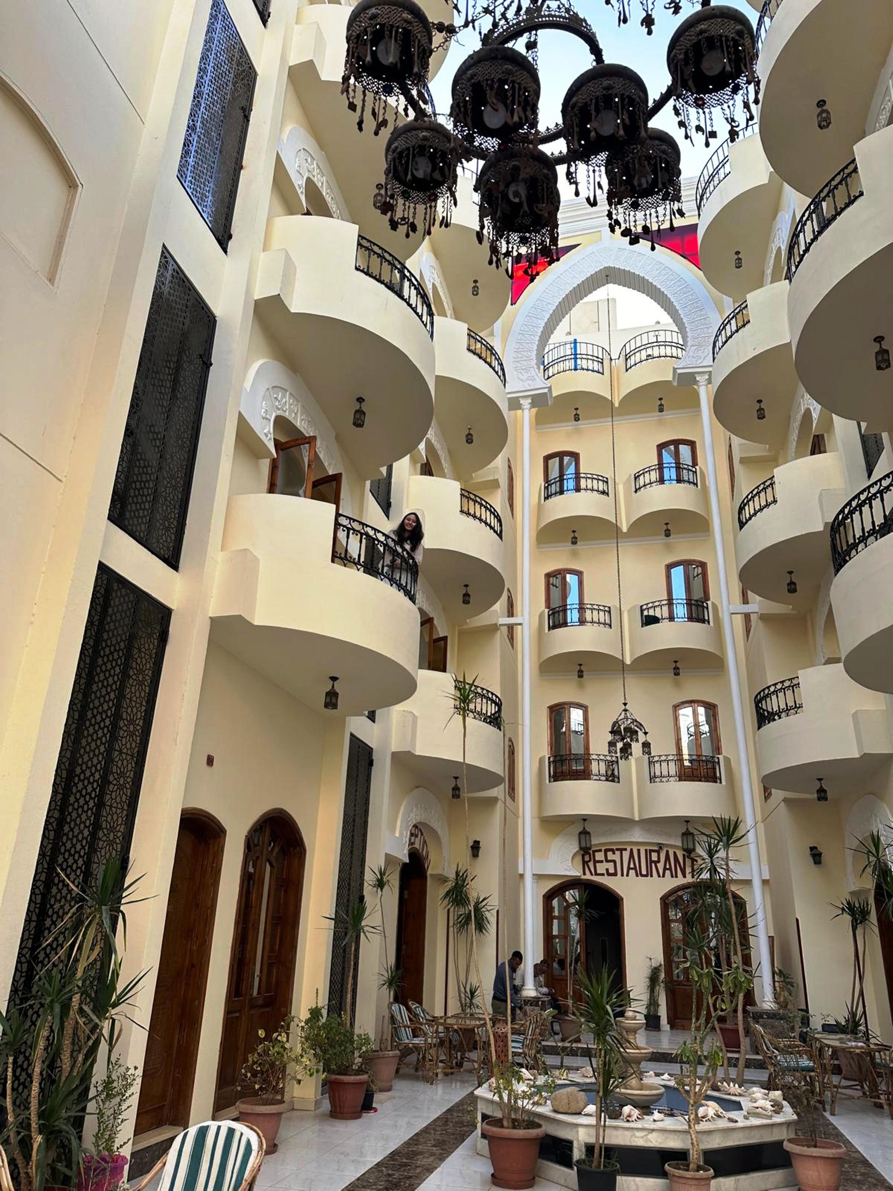 Un atrium d’hôtel à plusieurs niveaux, doté de balcons, d’une fontaine centrale et d’un restaurant.