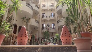 A multi-level atrium with balconies, potted plants, and a central open space.
