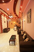 A spacious living area with a sofa set, a coffee table, and a chandelier.