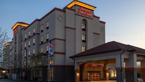 Ein Hampton Inn Suites Hotel mit freiem Zugang, amerikanischen Flaggen und einem freundlichen Schild.