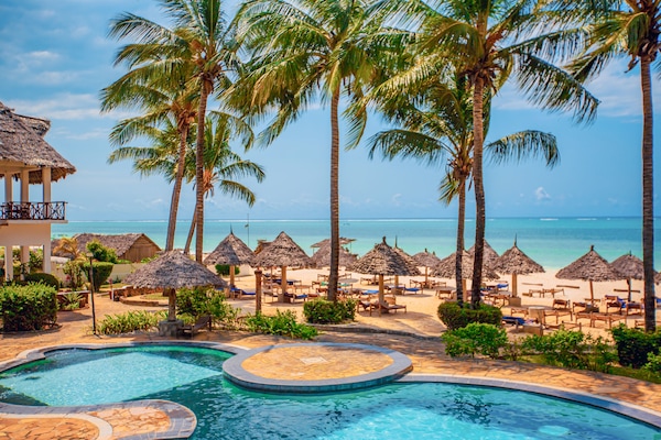 Een buitenzwembad, parasols bij het zwembad en ligstoelen