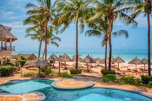 Una piscina al aire libre, sombrillas, tumbonas