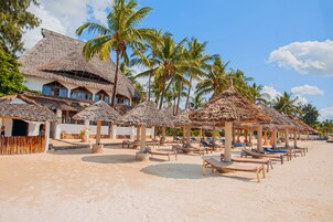 En la playa, sillas reclinables de playa, sombrillas, toallas de playa