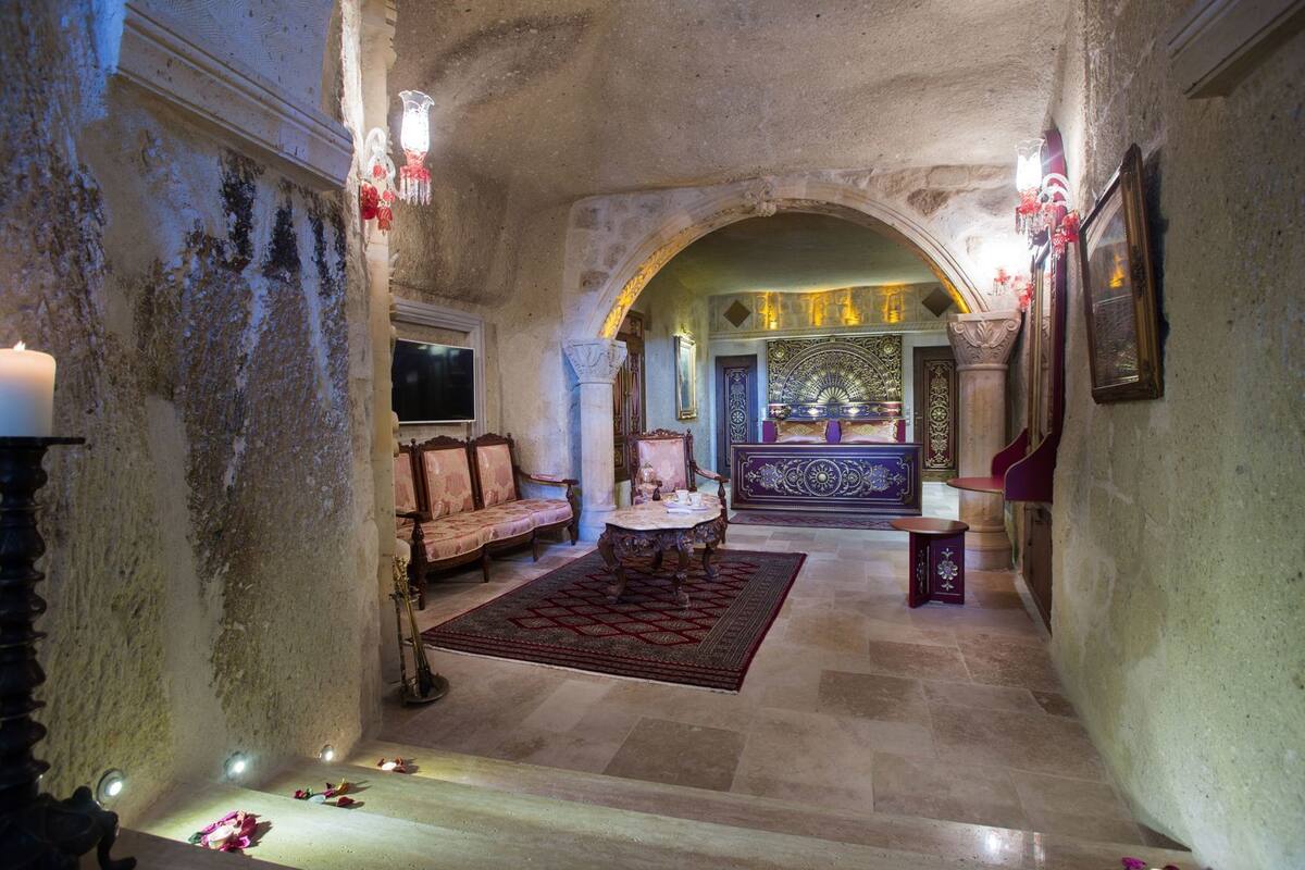 A grand hallway with a chandelier, a sofa, a table, and a decorative alcove with a golden fan.