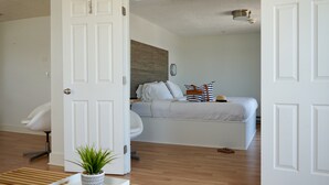 A bedroom with a bed, a chair, and a potted plant. - Inn on the Blues (York Beach)