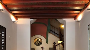 A reception area with a staircase leading to a second floor. - Hotel Convento del Giraldo (Cuenca)