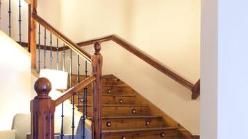 Un escalier en bois avec une rampe et un plafond décoratif.