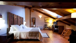 A bedroom with a wooden ceiling, a bed, a desk, and a chair. - Hotel Convento del Giraldo (Cuenca)