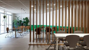 A modern office space with a long table and chairs, a wooden partition, and potted plants.