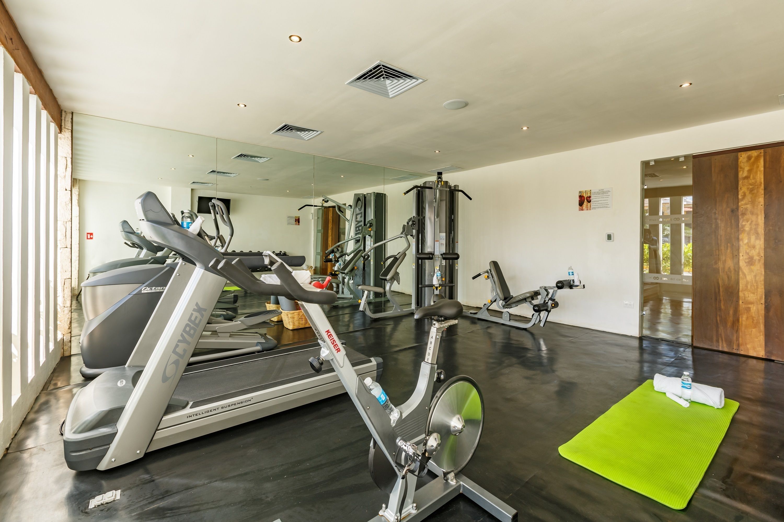 Une salle de sport équipée de tapis de course, de vélos d’appartement et d’appareils de musculation.