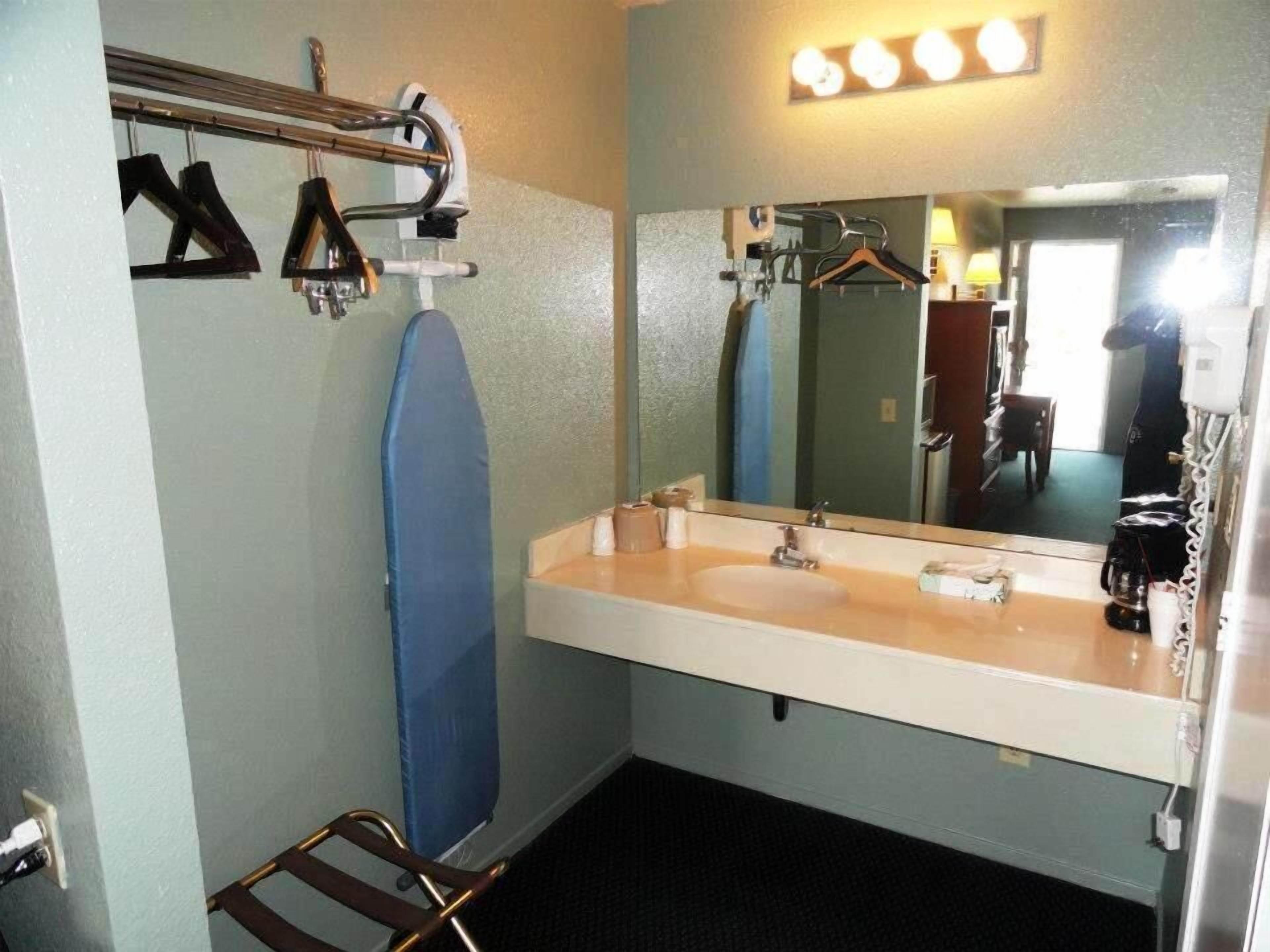 A bathroom with a sink, mirror, and towel rack.