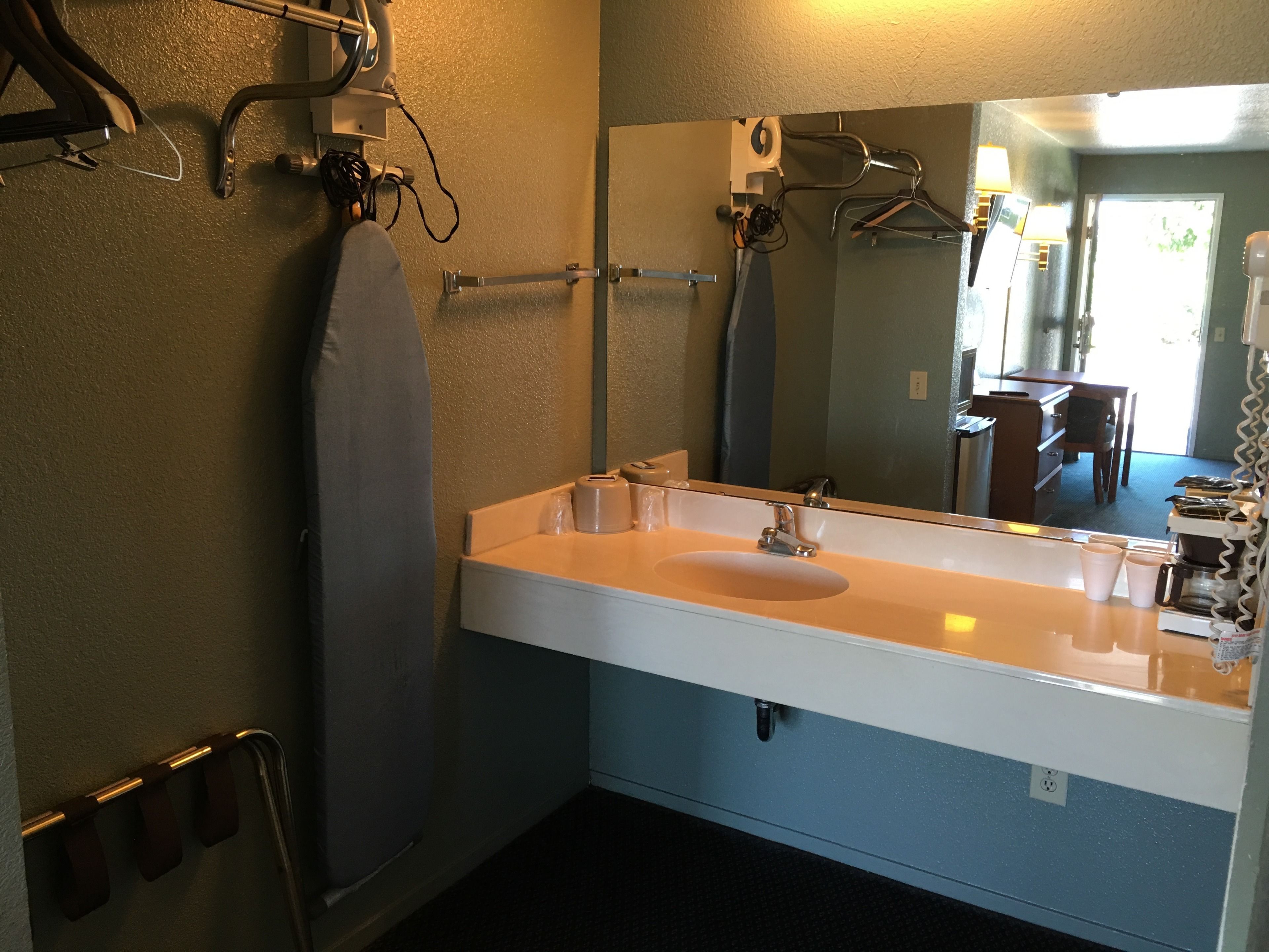 Un baño con lavamanos blanco, un espejo y cortina de ducha.