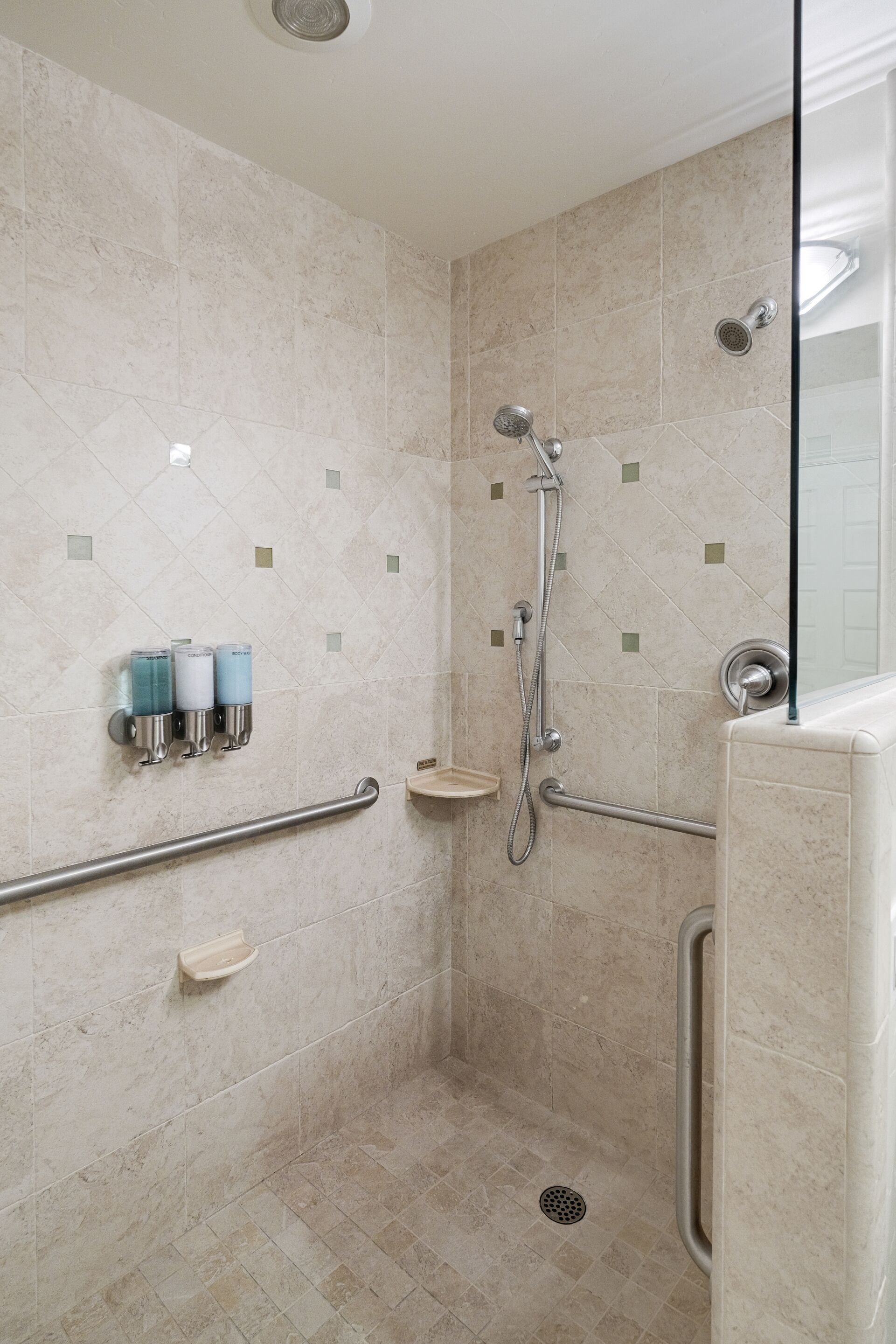A walk-in shower with beige tiles, a handheld showerhead, a handheld showerhead, a handheld showerhead, a handheld showerhead, a handheld showerhead, a handheld showerhead, a handheld showerhead, a handheld showerhead, a handheld showerhead, a handheld showerhead, a handheld showerhead, a handheld showerhead, a handheld showerhead, a handheld showerhead, a handheld showerhead, a handheld showerhead, a handheld showerhead, a handheld showerhead, a handheld showerhead, a handheld showerhead, a handheld showerhead, a handheld showerhead, a handheld showerhead, a handheld showerhead, a handheld showerhead, a handheld showerhead, a handheld showerhead, a handheld showerhead, a handheld showerhead, a handheld showerhead, a handheld showerhead, a handheld showerhead, a handheld showerhead, a handheld showerhead, a handheld showerhead, a handheld showerhead, a handheld showerhead, a handheld showerhead