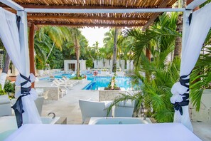 A pool area with lounge chairs and a pergola. - Oh! Cancun The Urban Oasis & Beach Club (Cancun)
