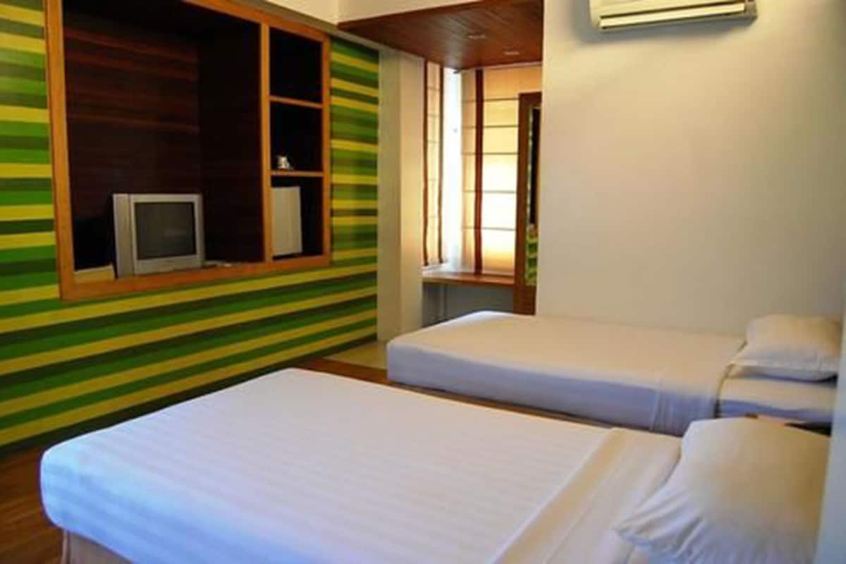 A hotel room with two beds, a television in a wooden cabinet, and a window with blinds.