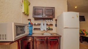 Cocina pequeña equipada con microondas, lavaplatos y refrigerador.
