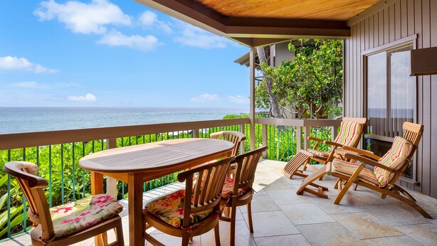 A wooden deck with a table and chairs, overlooking a body of water. - Castle Kanaloa at Kona (Kailua-Kona)
