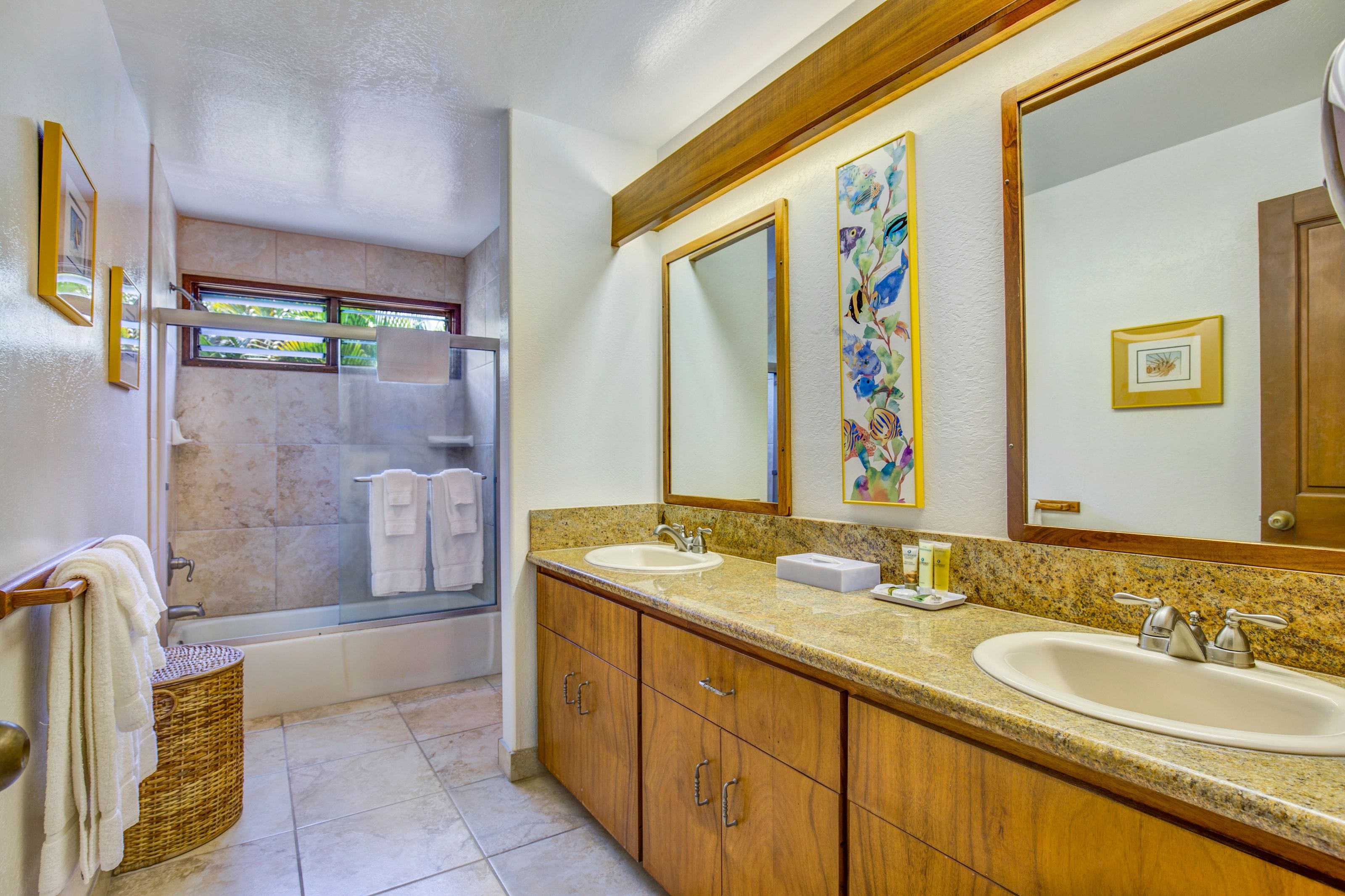 A bathroom with two sinks, a large mirror, and a shower area.