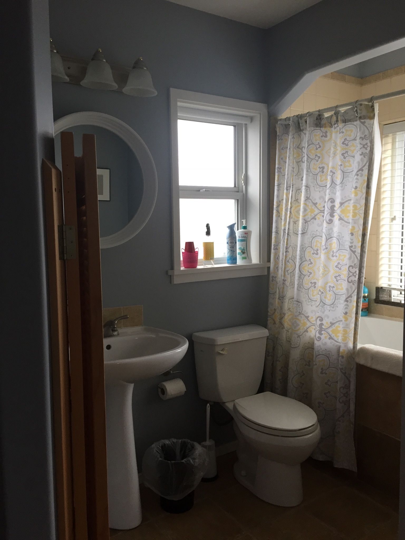 Een badkamer met een wastafel, toilet en raam.
