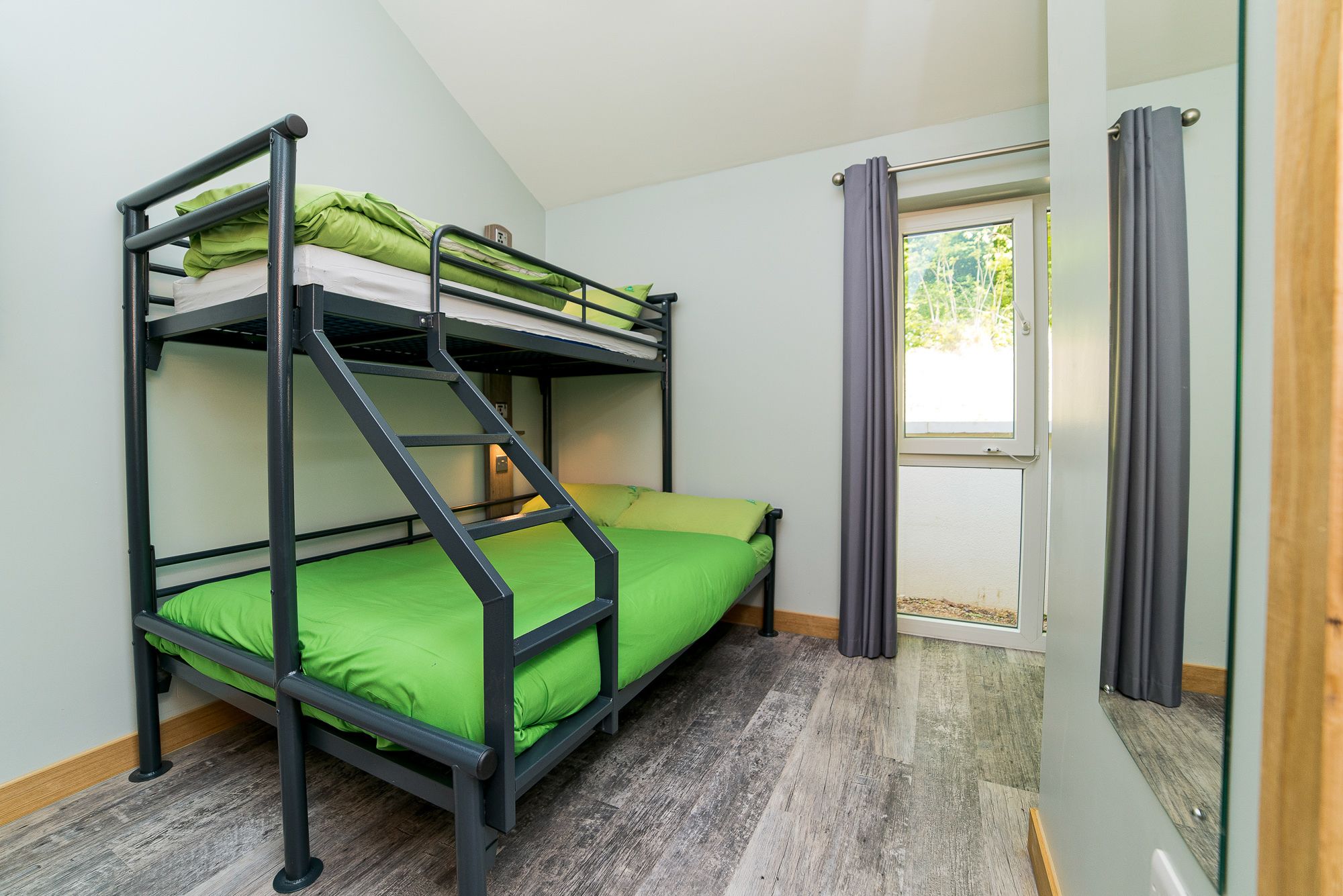 Habitación con literas, ventana y cortinas.