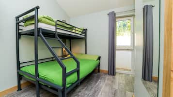 Habitación con literas, ventana y cortinas.