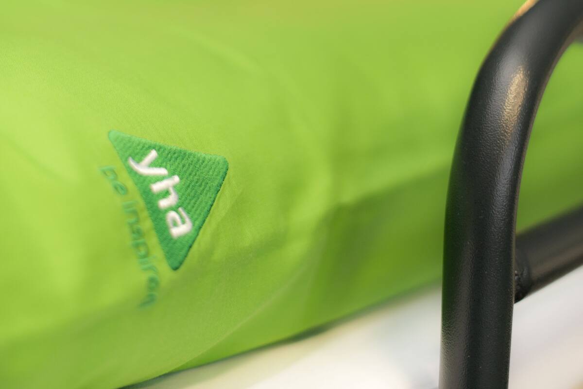 A close-up of a green bag with the logo "yha" and the text "be inspired".