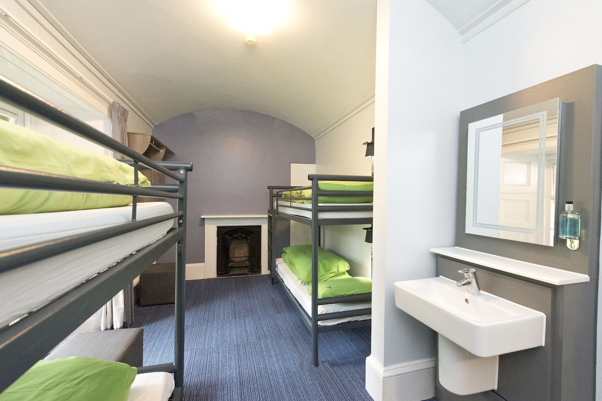 A bunk bed room with a sink and mirror.