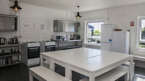 Una cocina moderna con armarios blancos, electrodomésticos de acero inoxidable e iluminación colgante.