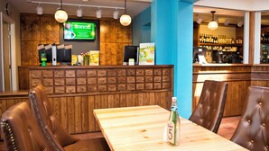 A restaurant with wooden booths, a bar area, and a television screen displaying an advertisement.