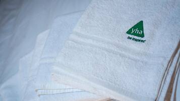 A stack of white towels with a logo and text on them.