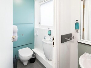 A compact bathroom with a toilet, sink, and a mirror. - YHA Castleton Losehill Hall - Hostel (Hope Valley)